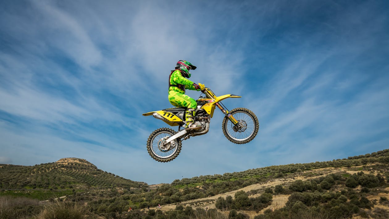 Person in green and yellow suit riding yellow motorcross dirt bike