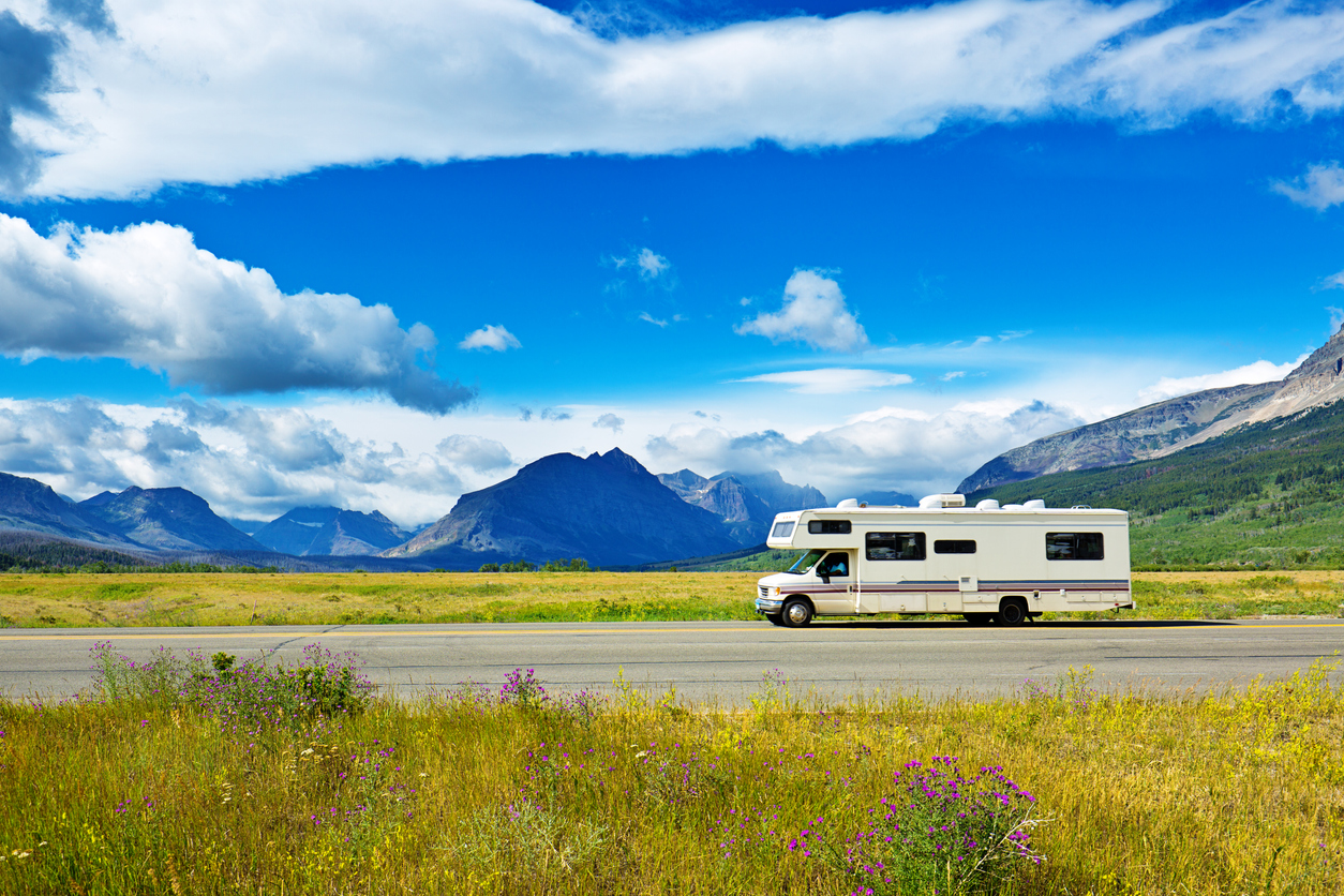 Visitors in camper RV traveling to Glacier National Park touring the park along the breathtaking 'Going To The Sun Road'. The scenic road wind through the national park along steep mountain cliffs and valleys.